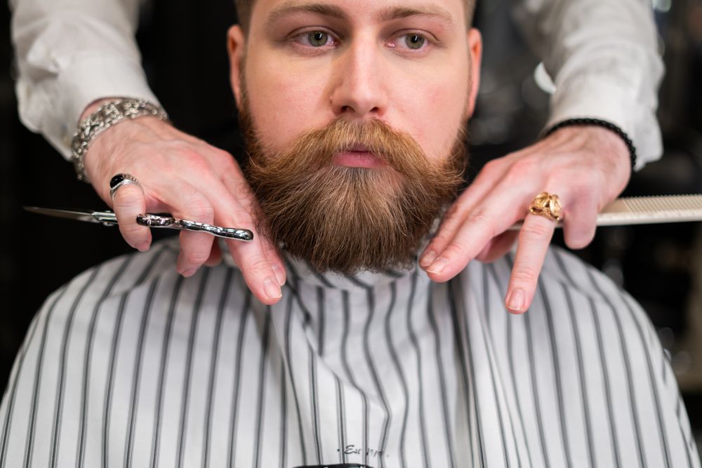 Barba completa recién esculpida, enmarcada por las manos del barbero