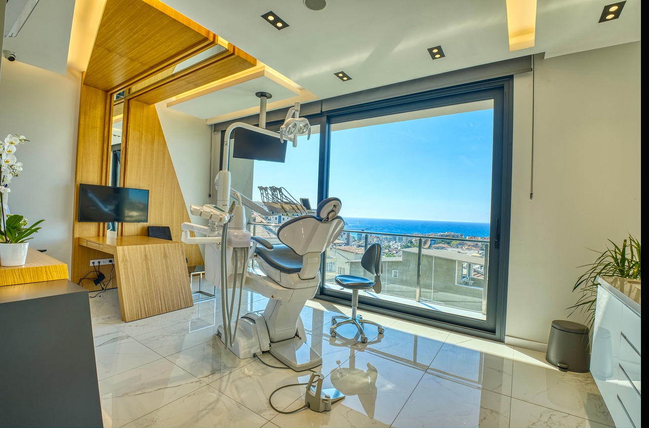 Consultorio dental con el sillón junto a un ventanal con vista al mar