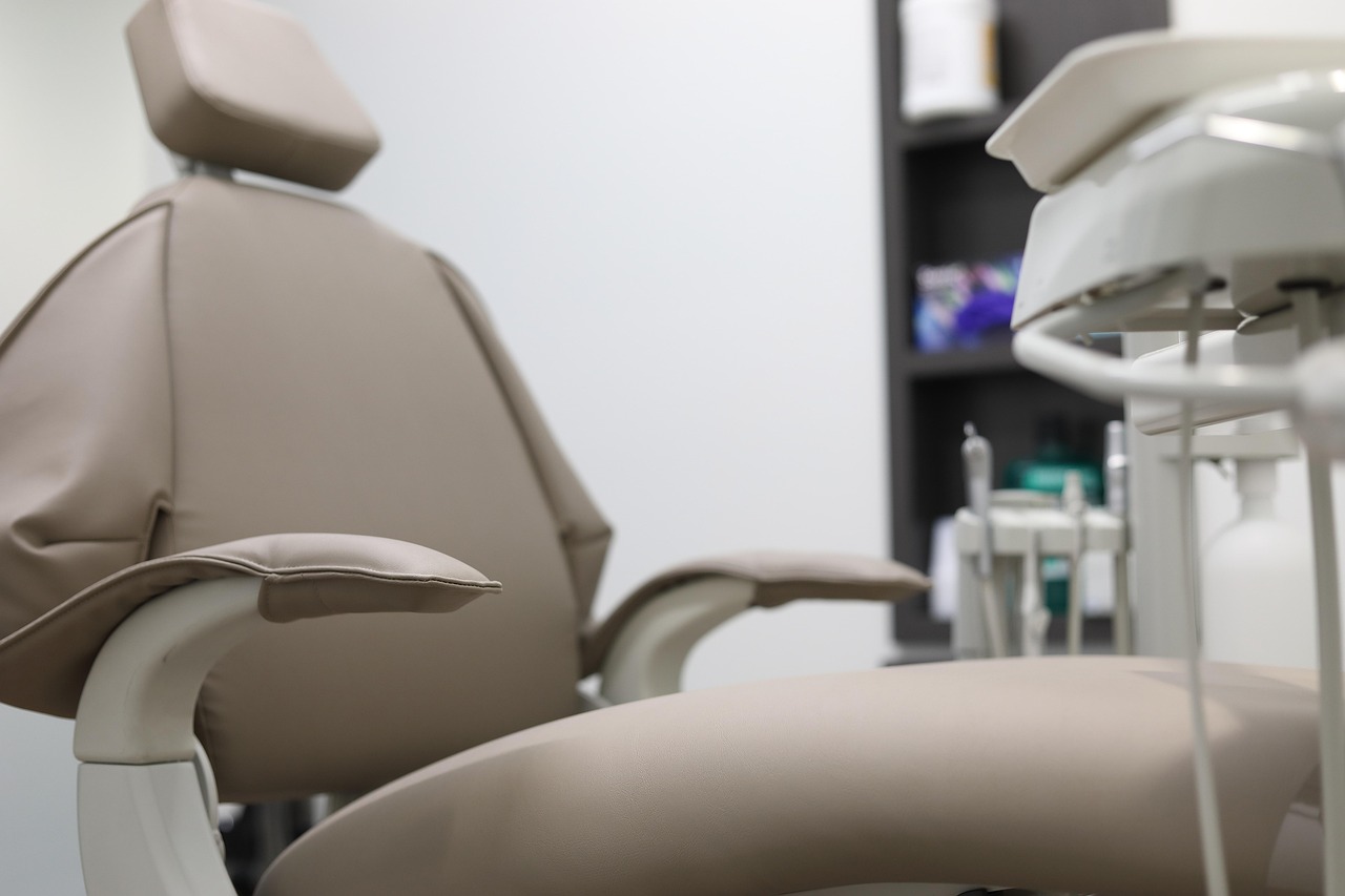 Sillón dental beige de cerca, con el cabezal y el apoyabrazos