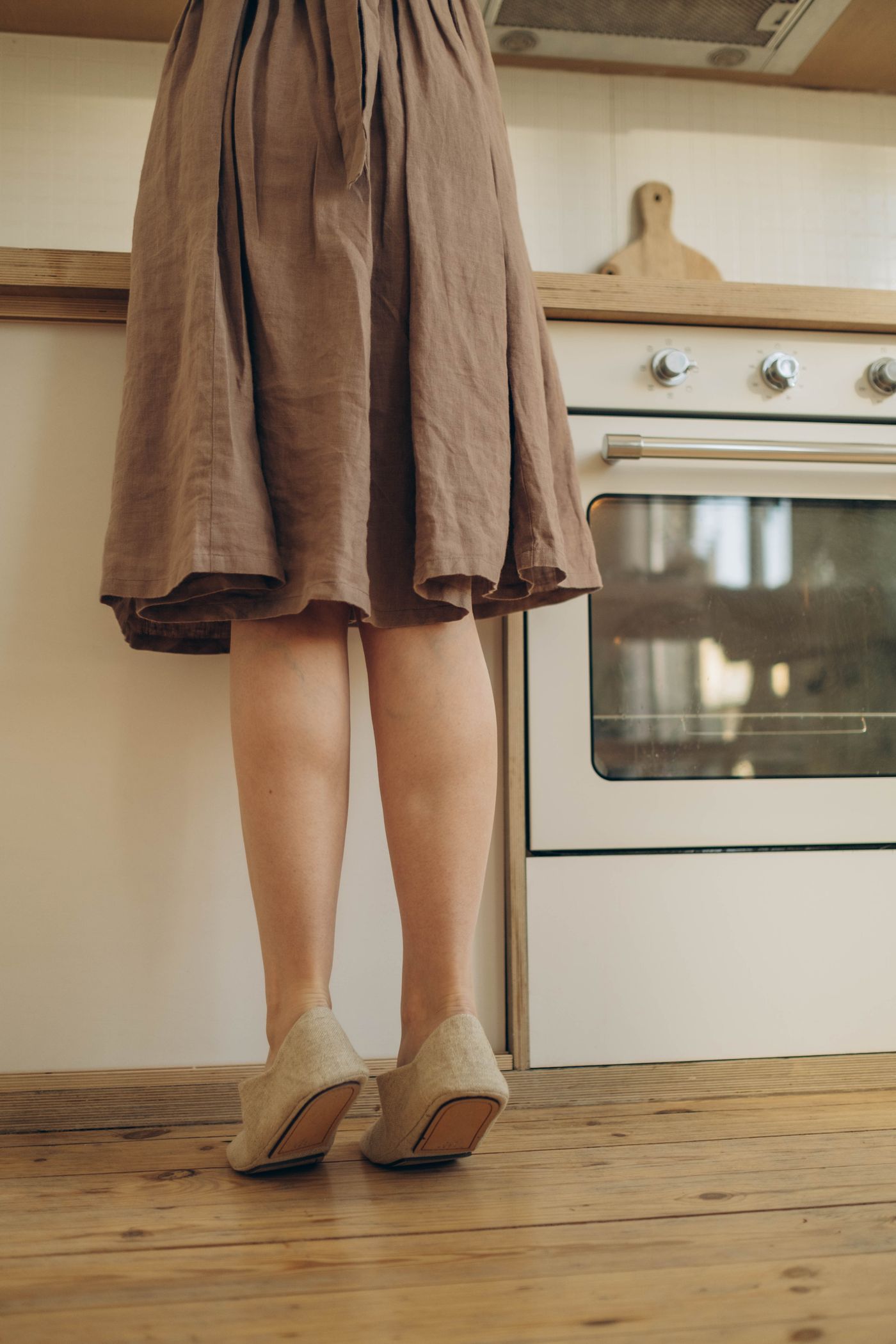 El vestido visto de la cintura para abajo: falda de lino plisada que cae por debajo de la rodilla
